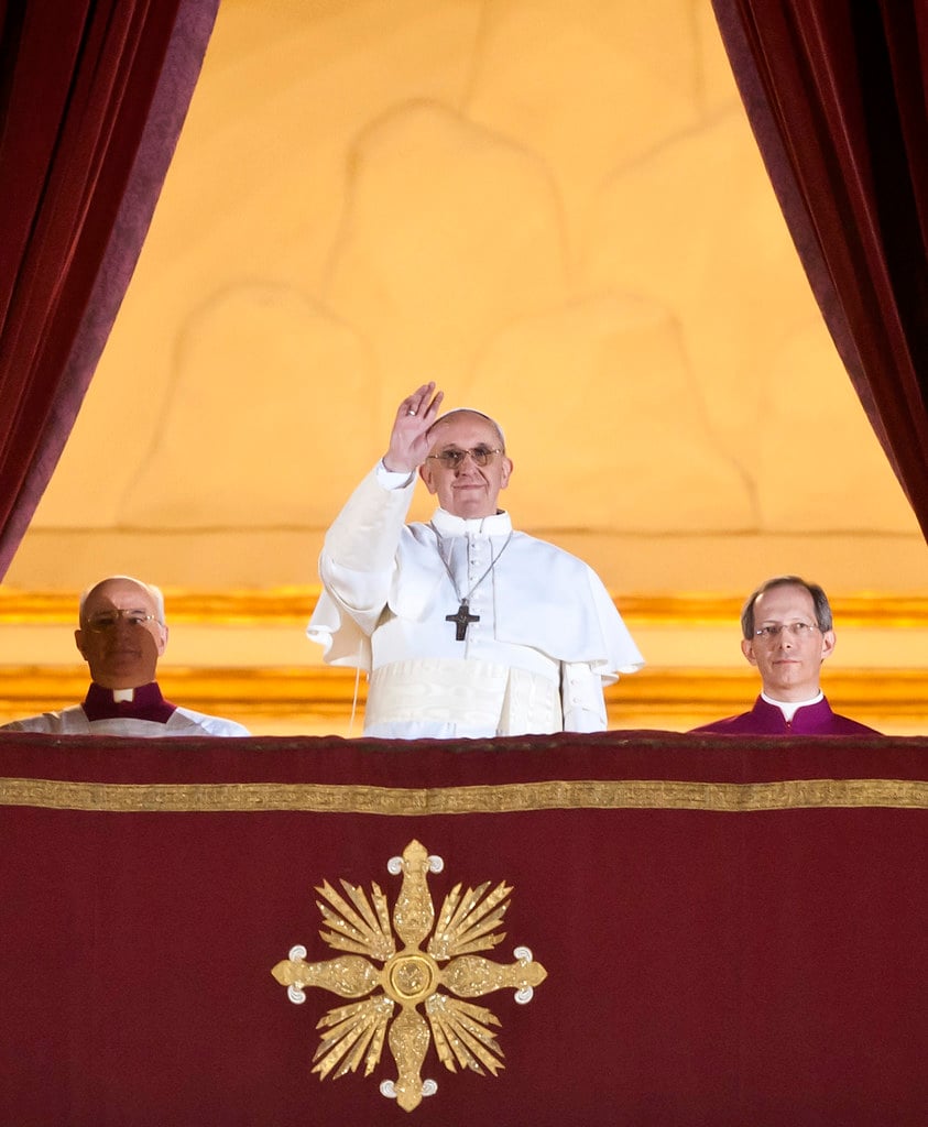 Pope Francis smiles and wave from a Vatican balcony after being selected Pope